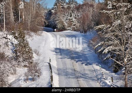 Chaussée glissante glacée sur une route pittoresque vallonnée de campagne dans le comté de Simcoe Ontario Canada Banque D'Images