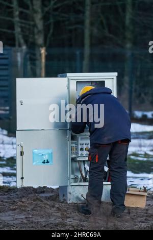 Un électricien effectue des travaux d'installation dans le tableau de distribution Banque D'Images