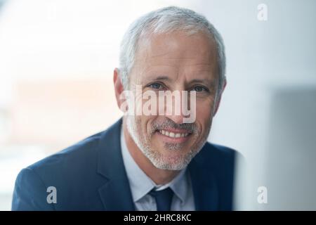Je représente le succès. Portrait d'un homme d'affaires mature assis dans un bureau moderne. Banque D'Images