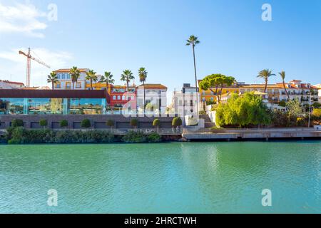 Des bâtiments colorés, dont des maisons et des boutiques, font face au fleuve Guadalquivir, dans le quartier de Triana, dans la ville analusienne de Séville, en Espagne. Banque D'Images