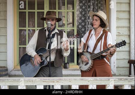 Homme et femme jouant une chanson dans la rue de l'ouest sauvage Banque D'Images