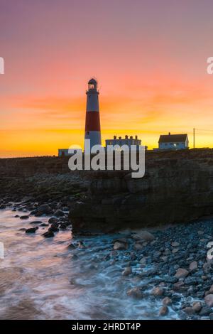 Portland Bill, Dorset, Royaume-Uni. 25th février 2022. Météo Royaume-Uni. Le ciel brille d'orange au-dessus du phare au coucher du soleil à Portland Bill à Dorset à la fin d'une chaude journée ensoleillée. Crédit photo : Graham Hunt/Alamy Live News Banque D'Images