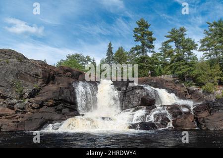 Vue d'un homme se tenant au bord de Muskoka High Falls, Bracebridge, Ontario, Canada Banque D'Images