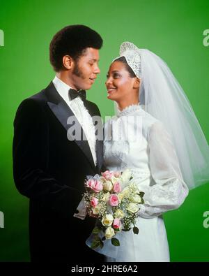 1970S PORTRAIT DE LA MARIÉE ET DU MARIÉ AFRO-AMÉRICAINS REGARDANT UN AUTRE HOMME À TUXEDO FEMME PORTANT UNE ROBE VOILE TENUE BOUQUET - KB8759 HAR001 HARS BOUQUET STYLE JEUNE ADULTE TRAVAIL D'ÉQUIPE ROSE FORTE JOIE HEUREUX STYLE DE VIE SATISFACTION CÉLÉBRATION FEMMES MARIÉ STUDIO COUP ROSES ÉVÉNEMENT CONJOINT ÉPOUX COPIE ESPACE AMITIÉ DEMI-LONGUEUR FEMMES MARIAGE PERSONNES AFRO SOINS HOMMES VOILE CÉRÉMONIE PARTENAIRE BUTS RÊVES LE BONHEUR LES STYLES GAI PERSONNALISÉS AFRO-AMÉRICAINS AFRO-AMÉRICAINS ET L'EXCITATION LA TRADITION NUPTIAL NUPTIAL OCCASION NOIR ETHNICITÉ MARIANT FIERTÉ DES CHEVEUX FACIAUX SOURIRES CONNEXION Banque D'Images