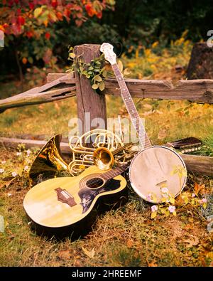 1970S ARRANGEMENT DES INSTRUMENTS DE MUSIQUE GUITARE BANJO CORNE FRANÇAISE ET TROMBONE PENCHÉE CONTRE LA CLÔTURE EN BOIS DE RAIL FENDU EN PLEIN AIR - KM5840 PHT001 HARS CONCEPT CONCEPT ENCORE LA VIE ARRANGEMENT ÉLÉGANT TROMBONE STRINGED CONCEPTS SYMBOLIQUES CRÉATIVITÉ RACINES TOGETHERNESS CORNE FRANÇAISE ANCIENNE REPRÉSENTATION Banque D'Images