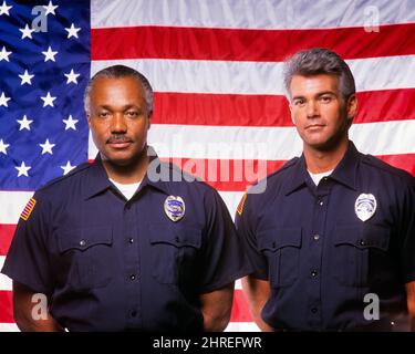 1990S DEUX POLICIERS AFRO-AMÉRICAINS ET CAUCASIENS SE TIENNENT DEVANT LE DRAPEAU DES ÉTATS-UNIS, PORTANT UN UNIFORME BLEU ET DES BADGES REGARDANT LA CAMÉRA - KP6083 DEL003 HARS 1 POLICIER VISAGE DIVERS SERVIR DRAPEAUX SÉCURITÉ TRAVAIL D'ÉQUIPE DIFFÉRENTS EMPLOIS STYLE DE VIE STUDIO SHOT COPIE ESPACE AMITIÉ DEMI-LONGUEUR PERSONNES INSPIRATION HOMMES ORDRE DE RISQUE OFFICER CONFIANCE EXPRESSIONS CONFIANCE COP CONTACT OEIL COMPÉTENCE OCCUPATION PROTÉGER LES COMPÉTENCES PROTECTION FORCE AFRO-AMÉRICAINS COURAGE AFRICAN-AMERICAN ET L'AUTORITÉ ETHNIQUE NOIRE PROFESSIONS POLITIQUES UNIFORMES CONCEPTUELS ÉTOILES ET RAYURES DIVERS OFFICIERS VIEILLE GLOIRE POLICIERS Banque D'Images