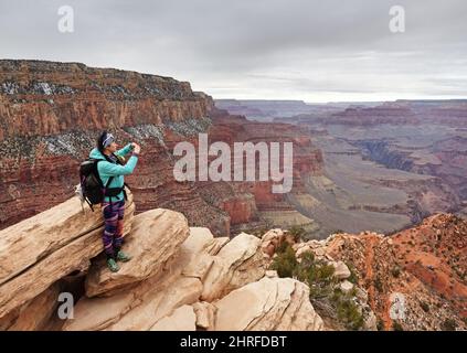 Femme asiatique prenant une photo avec son téléphone cellulaire à Ooh aah point sur le South Kaibab Trail dans le parc national du Grand Canyon Banque D'Images