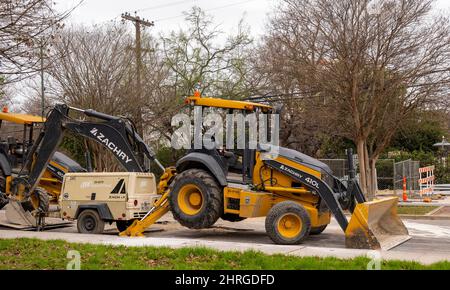 SAN ANTONIO, TX - 25 JANVIER 2020 : vue latérale des chargeurs frontaux, équipement lourd avec pelle rétro arrière sur un chantier de construction de routes sur la rue de la ville. Banque D'Images