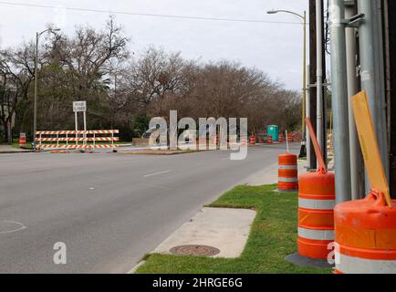 SAN ANTONIO, TX - 25 JANVIER 2020 : tonneaux d'avertissement orange et panneaux sur un chantier de construction de routes sur une rue de la ville. Banque D'Images