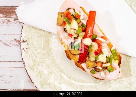 Une bruquette de pain rustique avec de la charcuterie, des champignons et de la vinaigrette, arrosée d'EVOO ou d'huile d'olive. Tapa typiquement espagnol. Banque D'Images