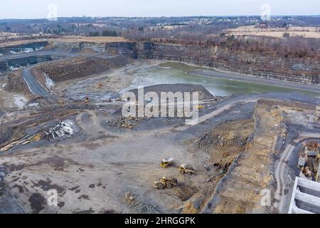 Les tombereaux pour applications minières lourdes qui se trouvent le long de la pelle hydraulique chargent la roche extraite dans le tombereau à benne basculante Banque D'Images