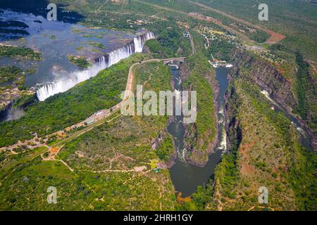 Victoria Falls entre le Zimbabwe et la Zambie, photo aérienne d'hélicoptère, forêt verte autour d'énormes cascades en Afrique. Pont Livingstone sur la riv Banque D'Images