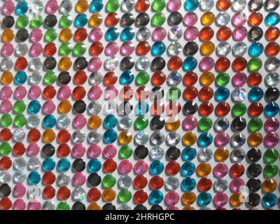 Arrière-plan de gros plan de pierres précieuses en plastique dans des couleurs vives assorties Banque D'Images