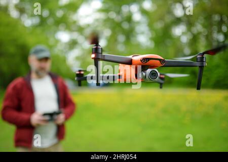 Homme regardant et naviguant dans un drone. Homme barbu qui commande le drone à distance. Banque D'Images