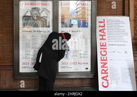 Un travailleur modifie un panneau d'affichage au guichet de Carnegie Hall pour annoncer que le chef d'orchestre russe Valery Gergiev ne conduira plus le VI Banque D'Images