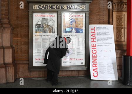 Un travailleur modifie un panneau d'affichage au guichet de Carnegie Hall pour annoncer que le chef d'orchestre russe Valery Gergiev ne conduira plus le VI Banque D'Images