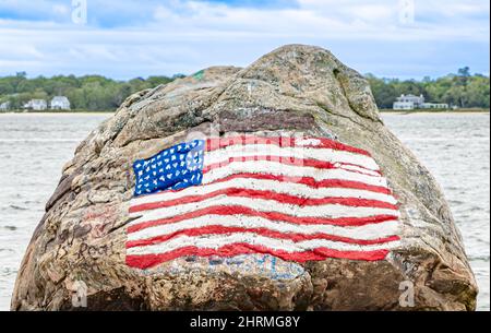 Un drapeau américain peint sur un gros rocher à Shelter Island, NY Banque D'Images