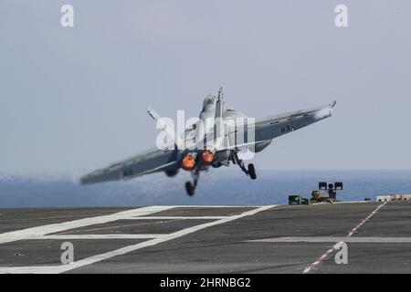 MER DES PHILIPPINES (fév 24, 2022) un F/A-18F Super Hornet, affecté aux « Black Aces » du Strike Fighter Squadron (VFA) 41, sort du pont de vol du porte-avions de la classe Nimitz USS Abraham Lincoln (CVN 72). Abraham Lincoln Strike Group est en cours de déploiement prévu dans la zone d'exploitation de la flotte américaine 7th afin d'améliorer l'interopérabilité par le biais d'alliances et de partenariats tout en servant de force d'intervention prête à l'emploi pour soutenir une région Indo-Pacifique libre et ouverte. (É.-U. Photo de la marine par le Spécialiste des communications de masse 3rd classe Javier Reyes) Banque D'Images