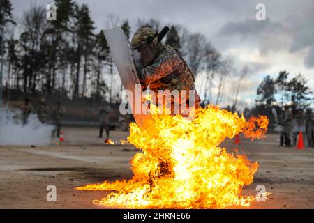 Hohenfels, Allemagne. 11th févr. 2022. Un soldat de l'armée américaine affecté au bataillon des gardes nationaux du Kentucky 1st, 149th Brigade d'infanterie, 116th Infantry Brigade combat Team, 29th Infantry Division, réagit à un cocktail Molotov tout en subissant une formation de phobie du feu au joint multinational Readiness Center, Hohenfels, Allemagne, 11 février 2022. La formation sur la phobie du feu est effectuée au cours des exercices de répétition de la mission avant le déploiement, afin de préparer et de familiariser les soldats à réagir aux incendies lors des émeutes de troubles civils. Crédit: Armée américaine/ZUMA Press Wire Service/ZUMAPRESS.com/Alamy Live News Banque D'Images