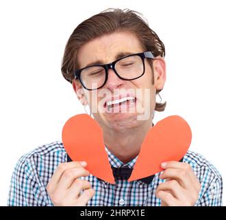 HES cassé. Un jeune homme pleure tout en tenant un coeur en papier déchiré. Banque D'Images