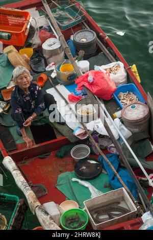 Une pêcheur locale vend des prises de petit bateau sur la digue du front de mer de Sai Kung, à Hong Kong Banque D'Images