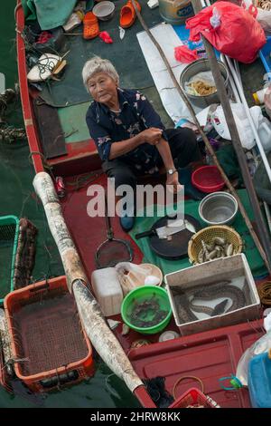 Une pêcheur locale vend des prises de petit bateau sur la digue du front de mer de Sai Kung, à Hong Kong Banque D'Images