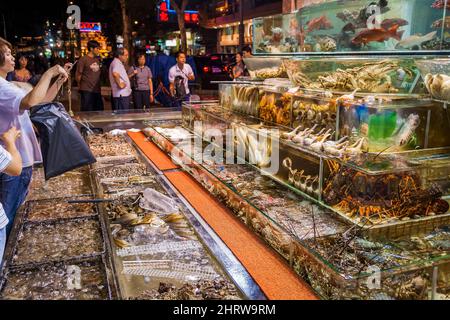 Poissons et fruits de mer vivants, y compris des crabes en fer à cheval en danger, exposés dans des chars devant un restaurant au bord de l'eau de Sai Kung, à Hong Kong Banque D'Images