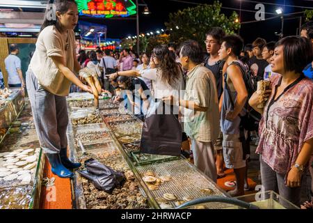 Un membre du personnel expose des palourdes de canard geocanard provenant des poissons et fruits de mer vivants dans des chars à l'extérieur d'un restaurant au bord de l'eau de Sai Kung, à Hong Kong Banque D'Images