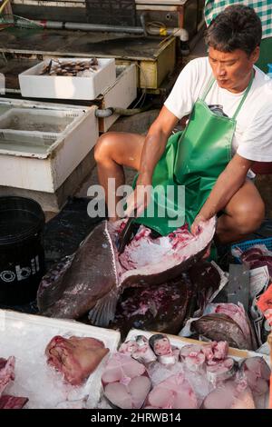 Un poissonnier local nettoie et coupe un gros poisson sur le front de mer de Cheung Chau, une île de Hong Kong (séquence - 7 de 8) Banque D'Images