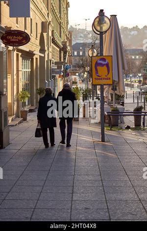 Stuttgart, Allemagne - 06 janvier 2022 : couple de personnes âgées marchant ensemble dans la ville. Les seniors font du shopping dans des vitrines noires. Vue arrière. Banque D'Images