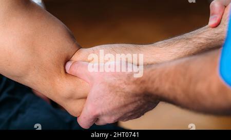Thérapeute physique massant le bras de l'homme Banque D'Images
