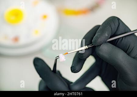 Technicien dentaire préparant la couronne de dent en céramique Banque D'Images