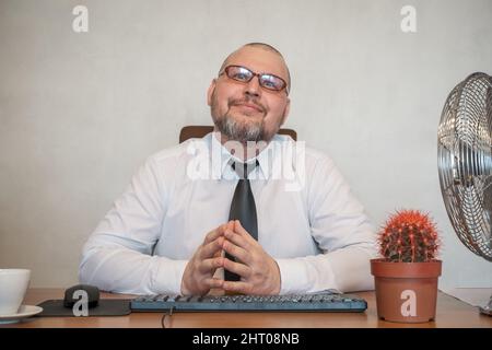 L'homme décrit comiquement le travail d'un homme d'affaires. Il montre le contentement et la joie sur son visage et sa posture. Banque D'Images