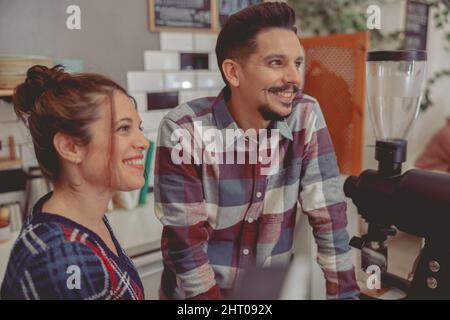 Photo en gros plan de l'homme et de la femme Barista communiquant avec les clients Banque D'Images