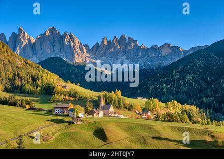 Vue aérienne de l'église Saint-Magdalena dans la vallée de Villnöss, faces nord et sommets du groupe Odle au loin, en automne. Banque D'Images