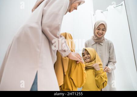 mère et fille musulmanes essayant une nouvelle robe dans les cabines d'essayage Banque D'Images