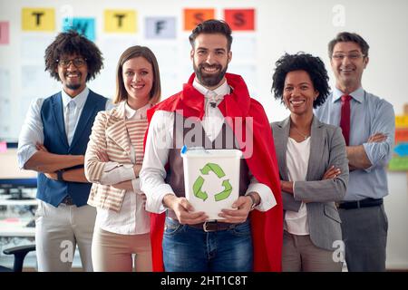 Un groupe d'employés heureux dans une atmosphère agréable dans le bureau pose pour une photo pour promouvoir le recyclage des déchets. Employés, travail, bureau Banque D'Images