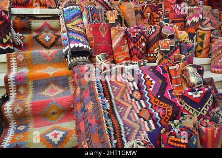 Tapis colorés, couvertures et souvenirs exposés sur les marches d'un bazar à Erbil, Irak. Banque D'Images