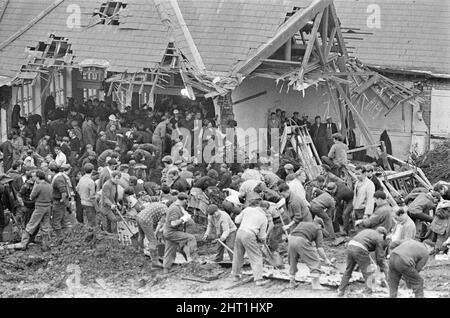 Aberfan - 21st octobre 1966 les hommes locaux et les services d'urgence creusent à la hâte dans la boue pour les survivants de la Pantans Junior School. Le désastre d'Aberfan a été l'effondrement catastrophique d'un pourboire de collierie dans le village gallois d'Aberfan, près de Merthyr Tydfil. Elle a été causée par une accumulation d'eau dans la roche accumulée et le schiste, qui a soudainement commencé à glisser en descente sous forme de lisier et a englouti la Pantglas Junior School ci-dessous, le 21st octobre 1966, tuant 116 enfants et 28 adultes. Le site de l'école d'origine est maintenant un jardin commémoratif. Photo prise le 21st octobre 1966The même Banque D'Images