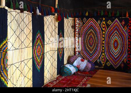 Erbil, Irak - 22 mars 2018 : tapis faits à la main suspendus au mur avec coussins dans un salon de thé, motifs colorés, Erbil, Irak. Banque D'Images