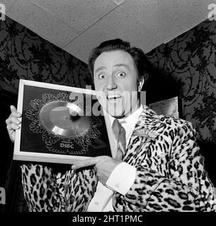 Le succès de Ken Dodd avec sa chanson 'Tears' se reflète dans ce disque d'argent, qui lui est présenté au London Palladium pour marquer les ventes de plus de 250 000 de la chanson. Ken est présent au Palladium dans 'doddy's here'. 19th octobre 1965. Banque D'Images