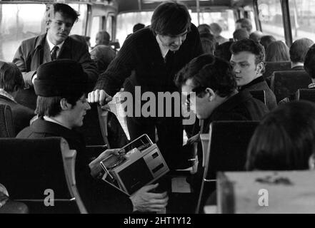 Groupe pop The FourMOST on tour le chanteur Brian O Hara (à gauche portant un chapeau) écoute un magnétophone portable avec Mike Millward lorsqu'il voyage à bord de l'autocar le 1965 février Banque D'Images