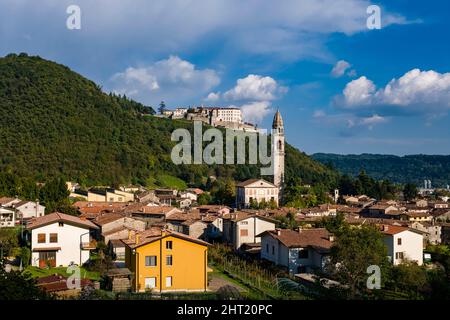 L'église Parrocchia dei Santi Pietro e Paolo du village de Valmareno, CastelBrando, un château médiéval, au loin. Banque D'Images