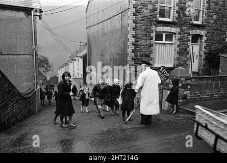 Abertillery, la plus grande ville de la vallée d'Ebbw Fach dans ce qui était le comté historique de Montockshire, aujourd'hui comté de Gwent. Une protection de franchissement routier qui aide les enfants à traverser la route. 17th février 1965. Banque D'Images