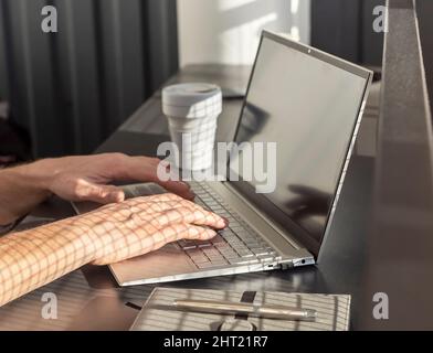 Les femmes travaillent de près sur un ordinateur portable et tapent un e-mail ou du texte pour travailler, étudier ou rechercher des données. Femme assise au bureau, à la maison ou à la table de café avec ordinateur, planificateur et gobelet à emporter. Photo de haute qualité Banque D'Images