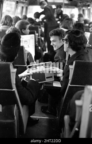 Groupe pop The FourMOST on tour le chanteur Brian O Hara (à gauche portant un chapeau) écoute un magnétophone portable avec Mike Millward lorsqu'il voyage à bord de l'autocar le 1965 février Banque D'Images