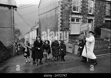 Abertillery, la plus grande ville de la vallée d'Ebbw Fach dans ce qui était le comté historique de Montockshire, aujourd'hui comté de Gwent. Une protection de franchissement routier qui aide les enfants à traverser la route. 17th février 1965. Banque D'Images