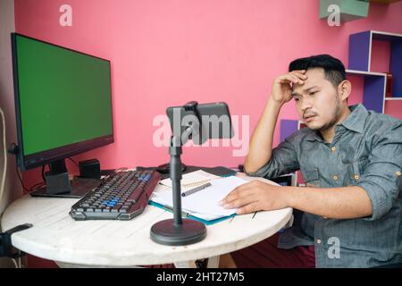 Femme asiatique freelance travaillant avec un ordinateur portable et un presse-papiers pendant la réunion Banque D'Images
