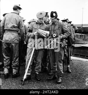 La chasse au bagnard échappé Frank Mitchell. Des hommes des 1st Argyll et Sutherland Highlanders ont pris part aujourd'hui à la chasse à l'homme. Chacun armé d'une poignée de cueillette, dirigée par Paddy Pearson, un joueur non armé, se répand sur une ligne de chemin de fer à Lydford, dans le Devon. Piper James Johnstone examine une carte avec un camarade armé d'une poignée de cueillette. 14th décembre 1966. Banque D'Images