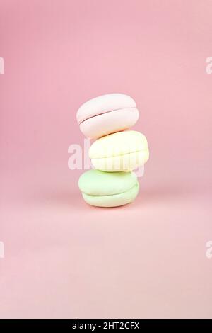 Les marshmallows français empilés multicolores ressemblent à des macarons sur fond de macarons français roses et colorés Banque D'Images